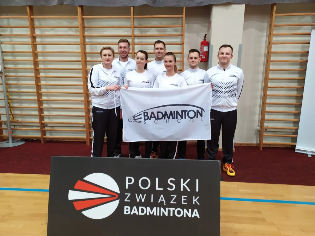 Zawodnicy Badminton School z flagą klubu na turnieju